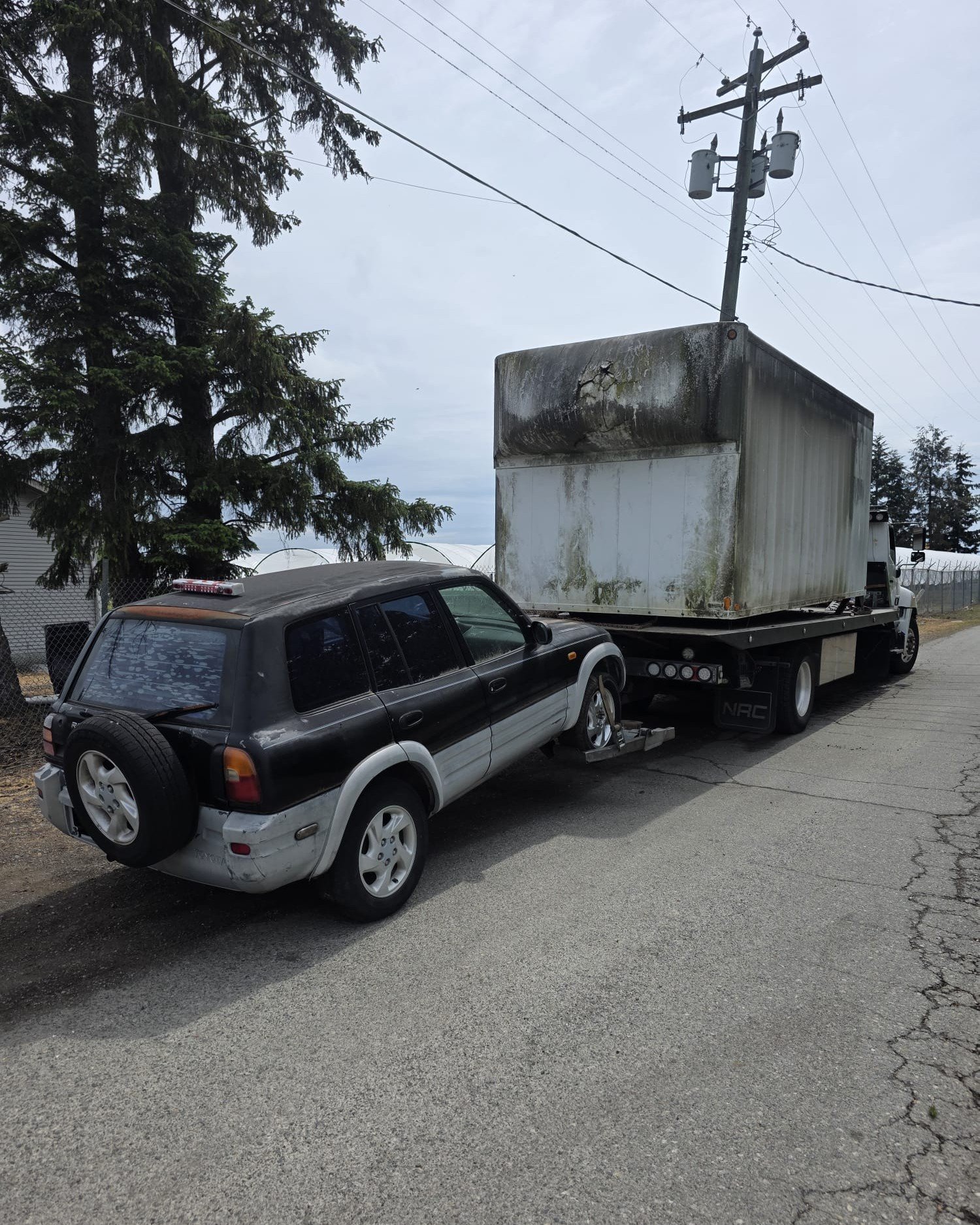 Junk vehicle waiting for free scrap car removal on a residential driveway