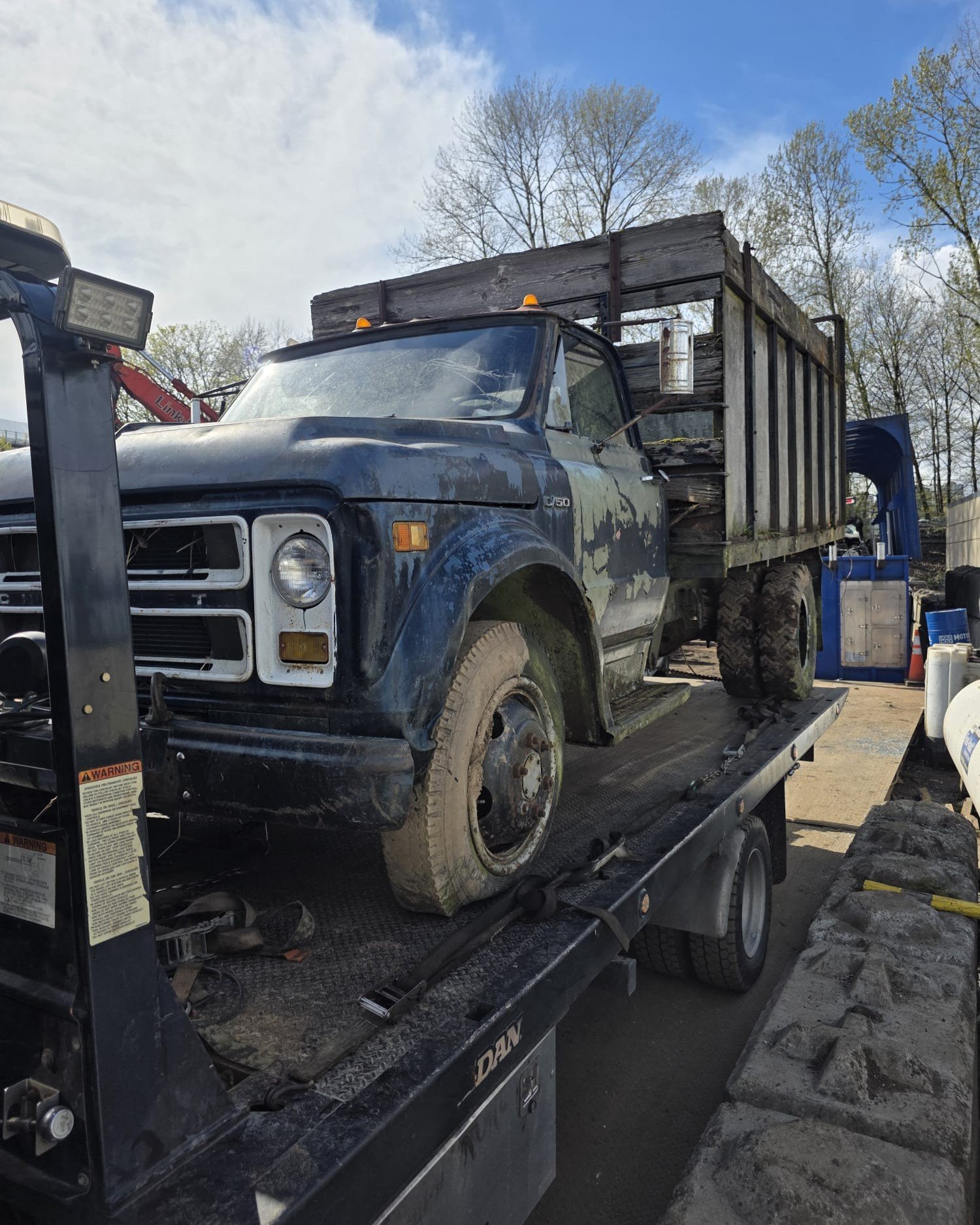 Tow truck loaded and ready to leave with a scrap car