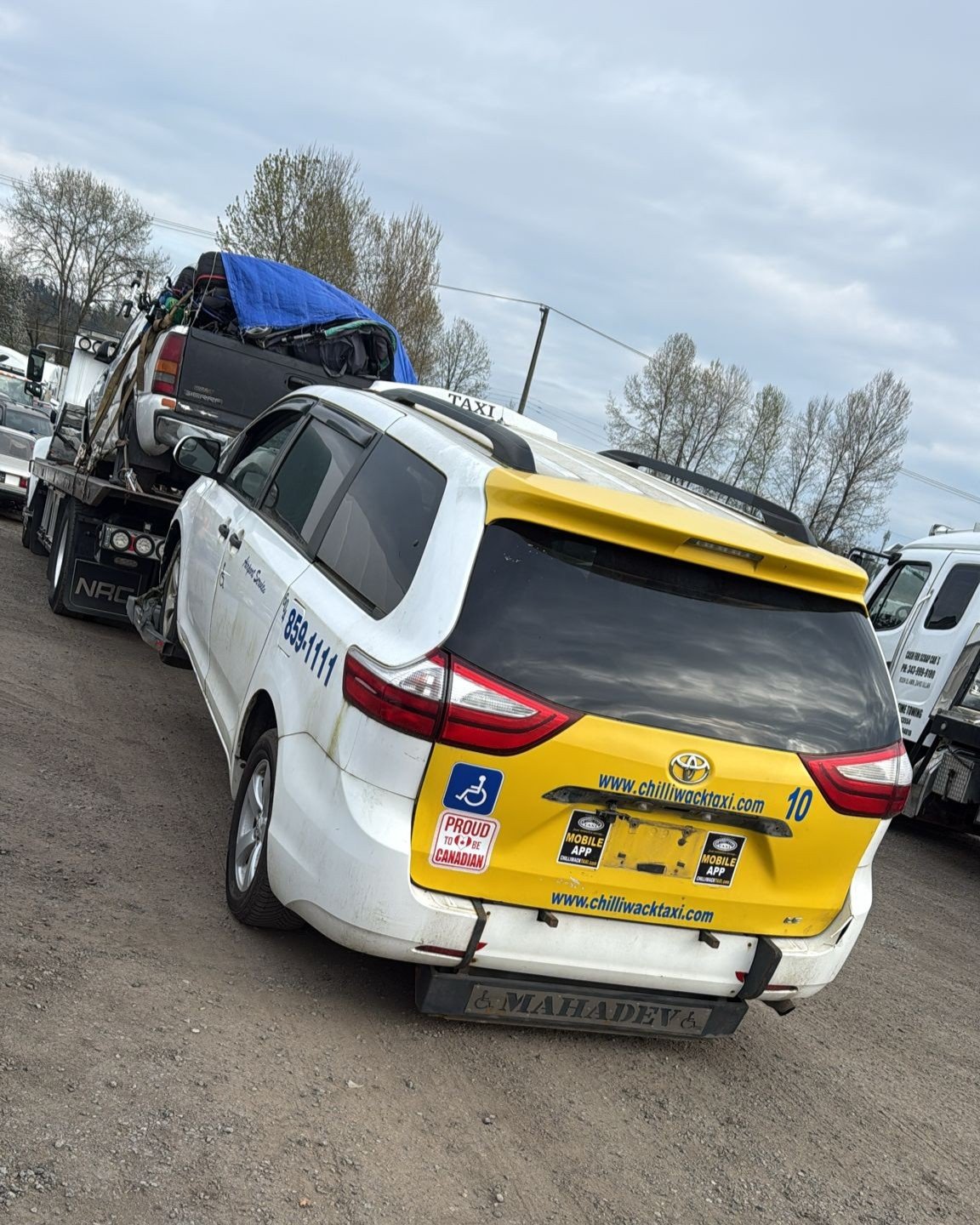 Flatbed tow truck loading a scrap car for removal in Lions Bay, BC